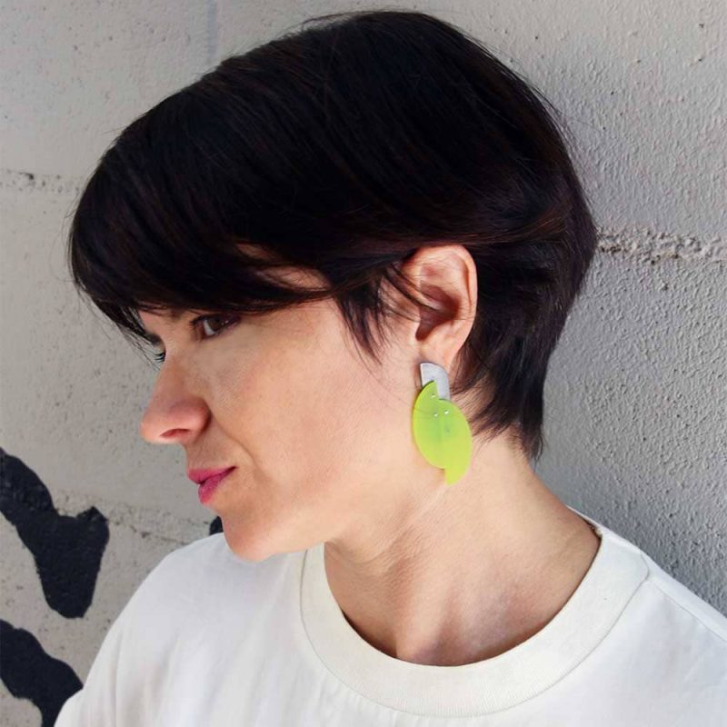 modelo con los pendientes fluor en forma de óvalo en verde